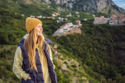 Woman in the mountains of Montenegro in warm clothes. Travel to Montenegro in spring, autumn, winter