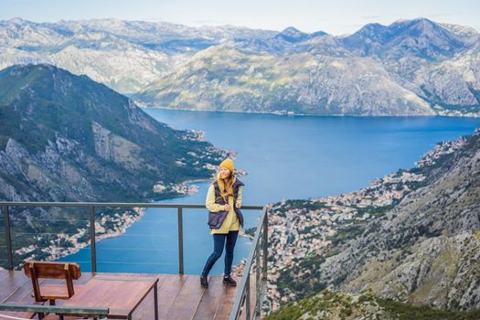 Woman tourist enjoys the view of Kotor. Montenegro. Bay of Kotor, Gulf of Kotor, Boka Kotorska and walled old city. Travel to Montenegro concept. Fortifications of Kotor is on UNESCO World Heritage List since 1979
