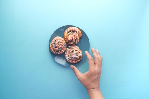 top view of hand pick cinnamon danish roll on table