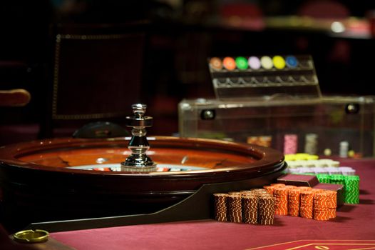 There is a red table with roulette chips in the casino