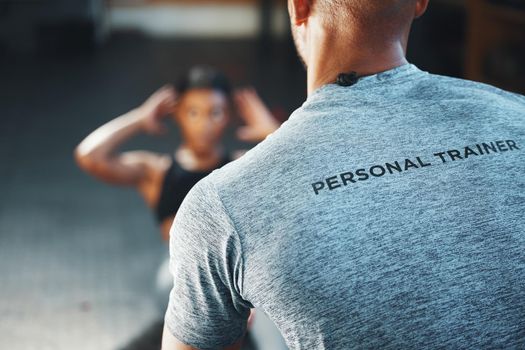 A trainer can make your exercise program a lot more effective. Closeup shot of a personal trainer assisting a client in a gym.