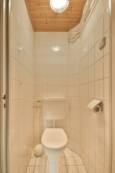 The interior of a toilet decorated with white tiles