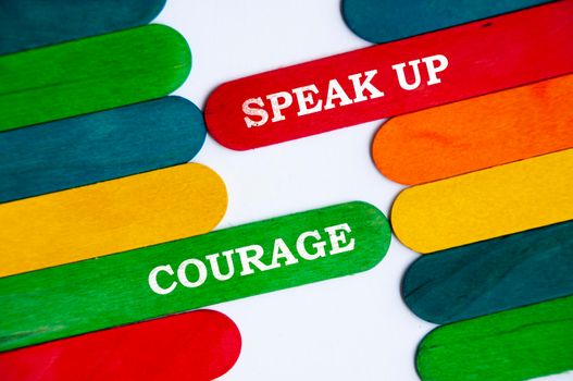 Speak up and courage text on colorful wooden stick. Conceptual