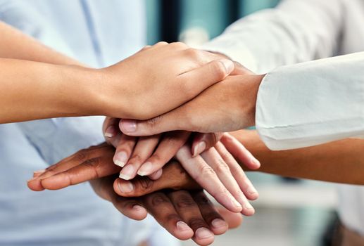 United in their pursuit of success. Cropped shot of a group of unrecognizable businesspeoples hands stacked while in a huddle in their office.