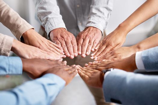 Get hands on, make things happen. Shot of a group of businesspeople joining hands in solidarity.
