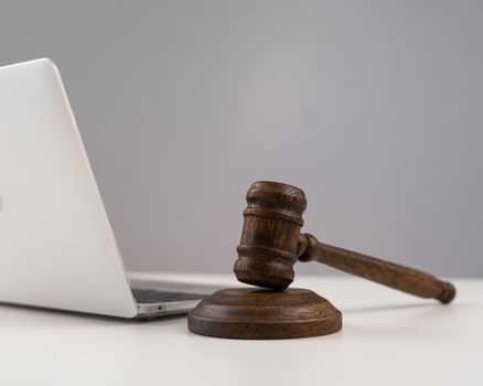 Judicial gavel and laptop on white background.