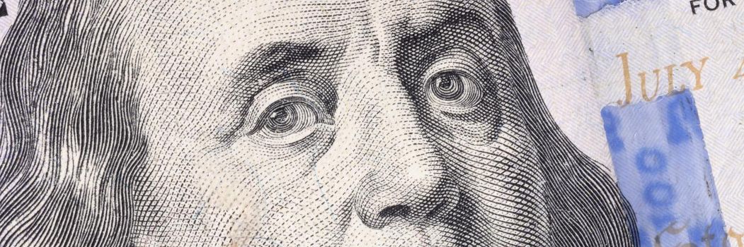 Closeup of Ben Franklin on one hundred dollar bill background
