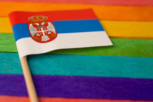 Serbia flag on rainbow background flag symbol of LGBT gay pride month  social movement rainbow flag is a symbol of lesbian, gay, bisexual, transgender, human rights, tolerance and peace.