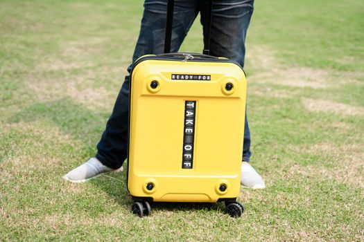 Asian woman lady holding yellow trolley suitcase with wording take off to travel in New year festival vocation.