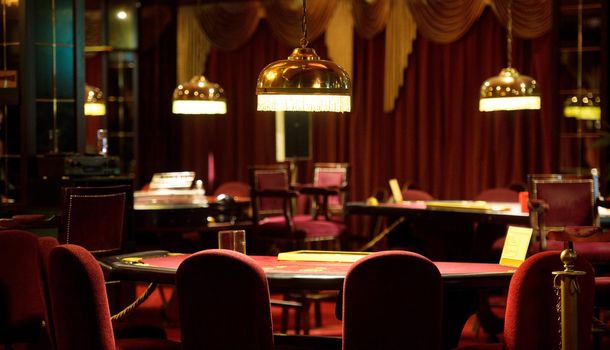 An empty blackjack table in a casino in red tones