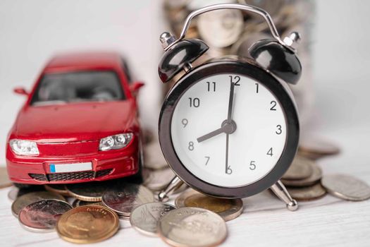 Car and alarm clock on coins, Car loan, Finance, saving money, insurance and leasing time concepts. 