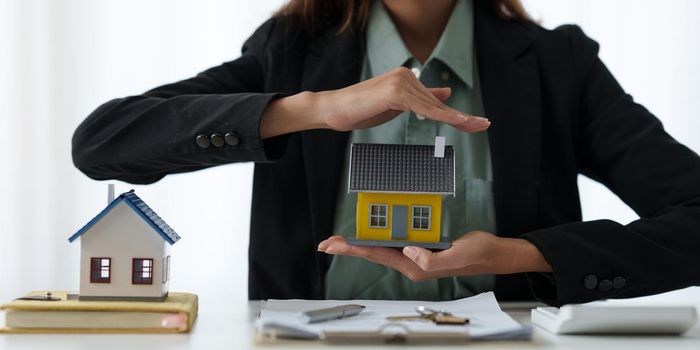 A woman holding and checking house model .Real Estate House Appraisal And Inspection and Insurance concept.