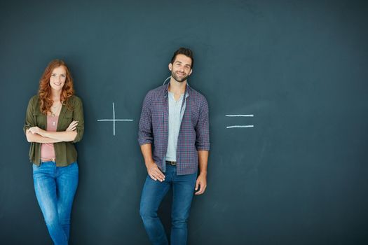 It can only go one of two ways. Shot of a young couple standing in front of a blackboard with symbols written on it.