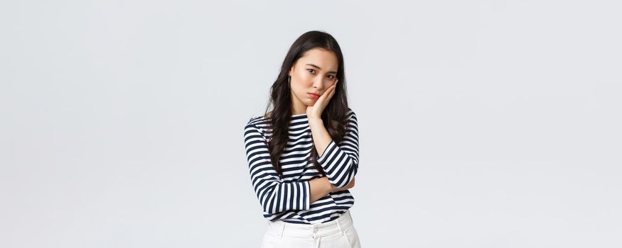 Lifestyle, beauty and fashion, people emotions concept. Annoyed and embarrassed young asian woman stare with dismay and judgement at camera, facepalm, standing white background