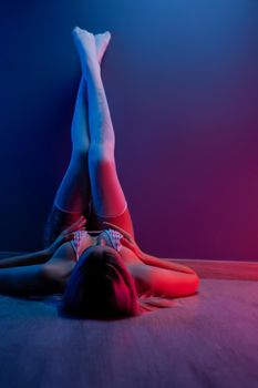 sexy young girl in underwear in neon light by the wall