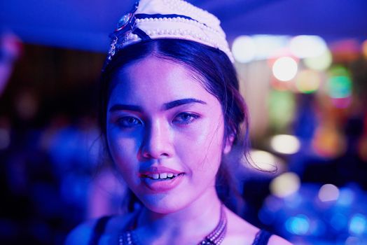 Thai nightlife. Portrait of a young woman working in a neon lit Thai nightclub.