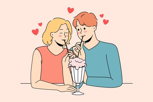 Happy couple on date enjoy milkshake together
