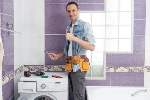 man repairs a washing machine