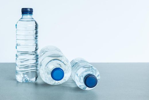 three plastic bottles filled with mineral water on white background