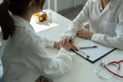 Asian female doctor in white medical uniform consult female patient in private hospital. woman therapist speak talk with woman client on consultation in clinic