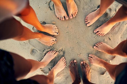 Sandy toes and salty seas is just what we need. Shot of young people hanging out at the beach.