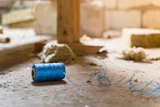 Blue polypropylene construction thread lies on the floor at a construction site close-up. Blue twine thread