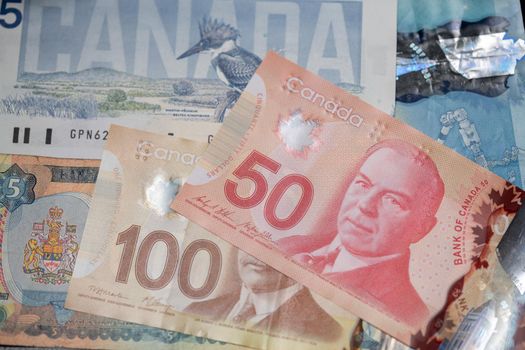 Canadian Dollar Banknotes piled up, new and old CAD bills