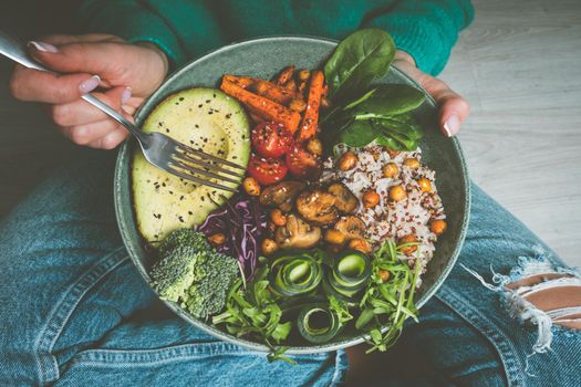 Woman holding plate with vegan or vegetarian food. Healthy diet. Healthy vegetable dinner or lunch. Tasty buddha bowl. Healthy vegan eating