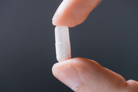 close up. white round tablet in a human hand .