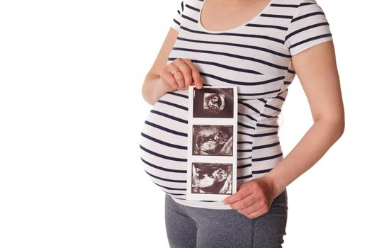 Pregnant woman standing and holding her ultrasound baby scan