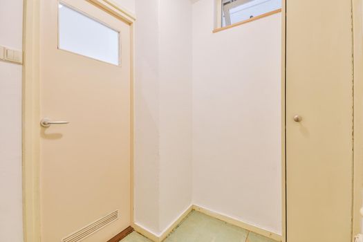 Doorway of modern apartment with white walls and narrow wardrobe