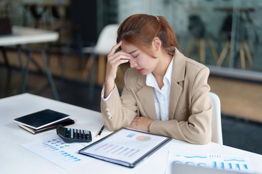 Burnout Syndrome. Portrait of Asian Business Woman feels uncomfortable working. Which is caused by stress, accumulated from unsuccessful work And less resting body. Consult a specialist psychiatrist.