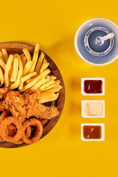 Fast food dish on yellow background. Fast food set fried chicken and french fries. Take away fast food.