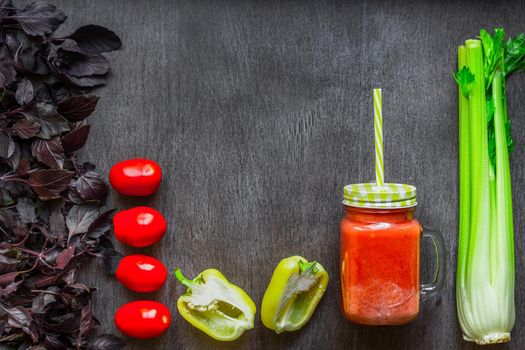 Spicy tomato drink with celery and pepper. Tomato drink in jar surrounded of fresh vegetables on a wooden table