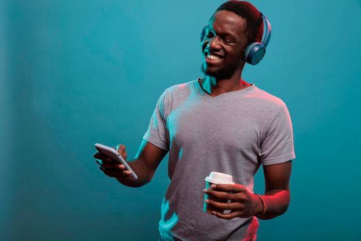 Excited model listening to music played on smartphone with headset