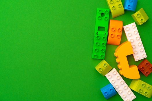Details of kids plastic constructor on green background