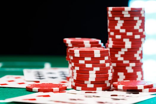 Red playing chips and cards on poker table