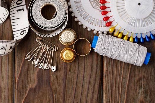 Threads and sewing accessories on brown wooden table