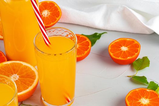 Glass of orange juice with red straw on table