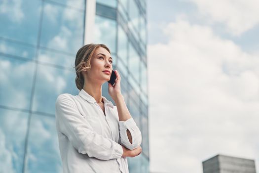 Businesswoman successful woman business person standing outdoor corporate building exterior. Pensive caucasian confidence professional business woman middle age