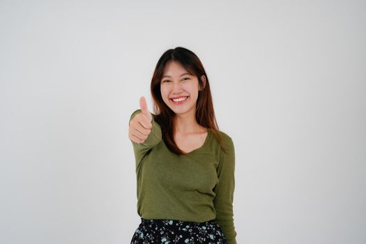 Young asian woman standing over isolated white background happy face smile looking at the camera. Positive person.