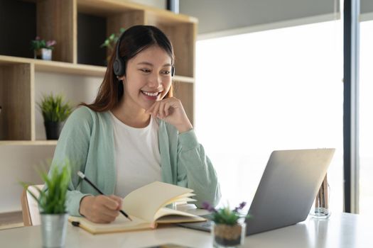 Concentrate asian gial freelancer wearing headset, communicating with client via video computer call. Millennial pleasant professional female tutor giving online language class.