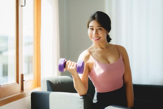 Beautiful woman exercising with dumbbells at home. bodybuilding, fitness, sport, weightlifting concept.