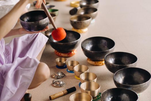 Close-up of a Tibetan singing bowl in your hands - Translation of mantras: transform your impure body, speech and mind into a pure exalted body, speech and mind of a Buddha