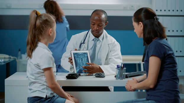 General practitioner showing x ray diagnosis on tablet