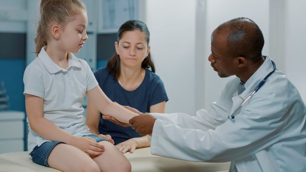 African american specialist examining injury of little kid in cabinet