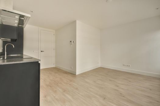 A spacious empty room with a small kitchen