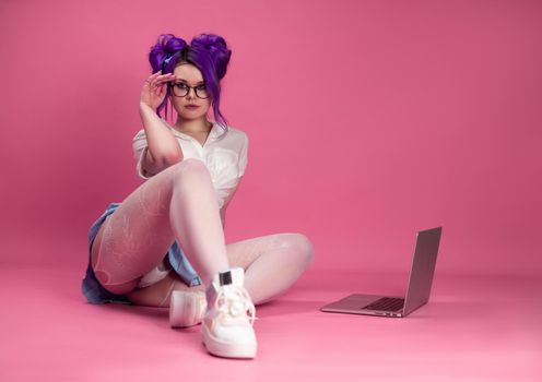 sex and a bright girl in summer clothes poses sexually showing underwear and stockings on the floor with a laptop
