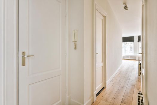 A spacious straight corridor with several doors on the sides
