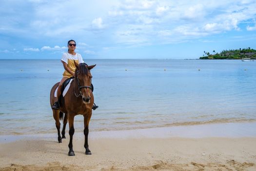 horse riding on the beach, woman on horse on the beach during luxury vacation in Mauritius